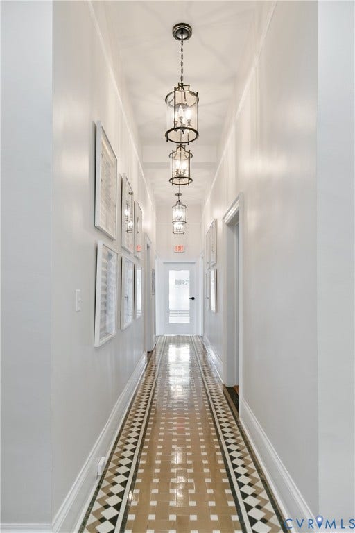 2800 Patterson Avenue, Richmond, VA 23221 Hallway featuring geometric pattern tile flooring, a series of three cylindrical metal pendant light fixtures, and a glass-panel door