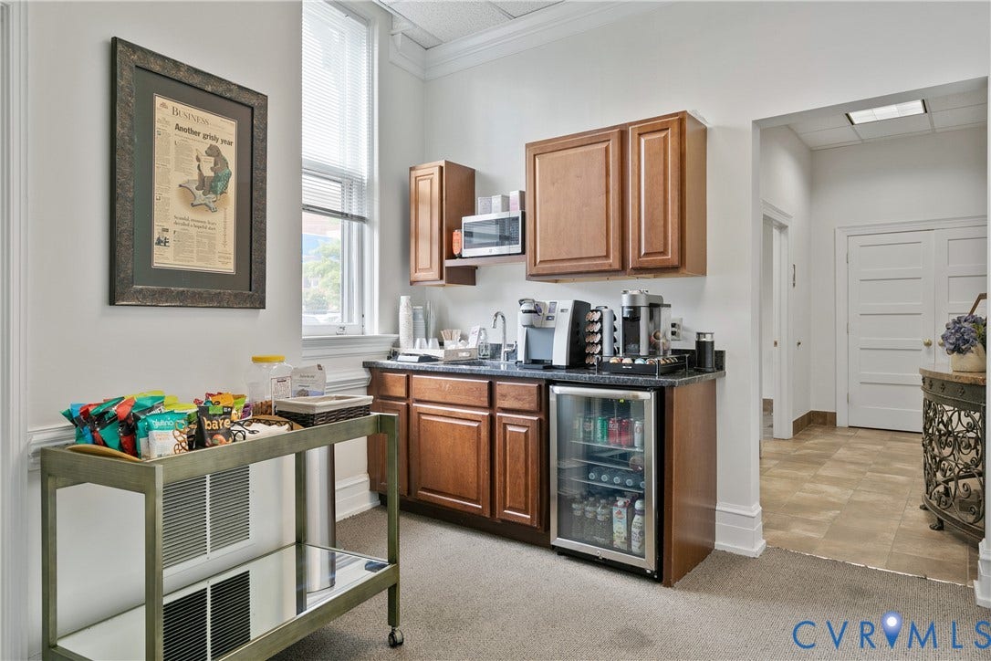 2800 Patterson Avenue, Richmond, VA 23221 Kitchenette featuring wood cabinetry, dark stone countertops, stainless steel undermount sink, built-in microwave, and integrated under-counter beverage refrigerator