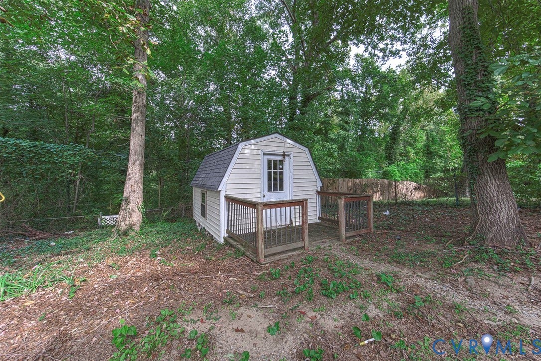 2408 Swartwout Avenue, Woodland Hills, Henrico, VA 23228 Gambrel-roofed exterior storage structure with light-colored vinyl siding, integrated wood-railed deck, and glass-paned entry door