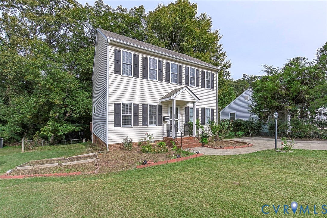 2408 Swartwout Avenue, Woodland Hills, Henrico, VA 23228 Two-story colonial exterior featuring vinyl siding, dark-toned shutters, a covered front entry with brick-stepped stoop, and concrete driveway