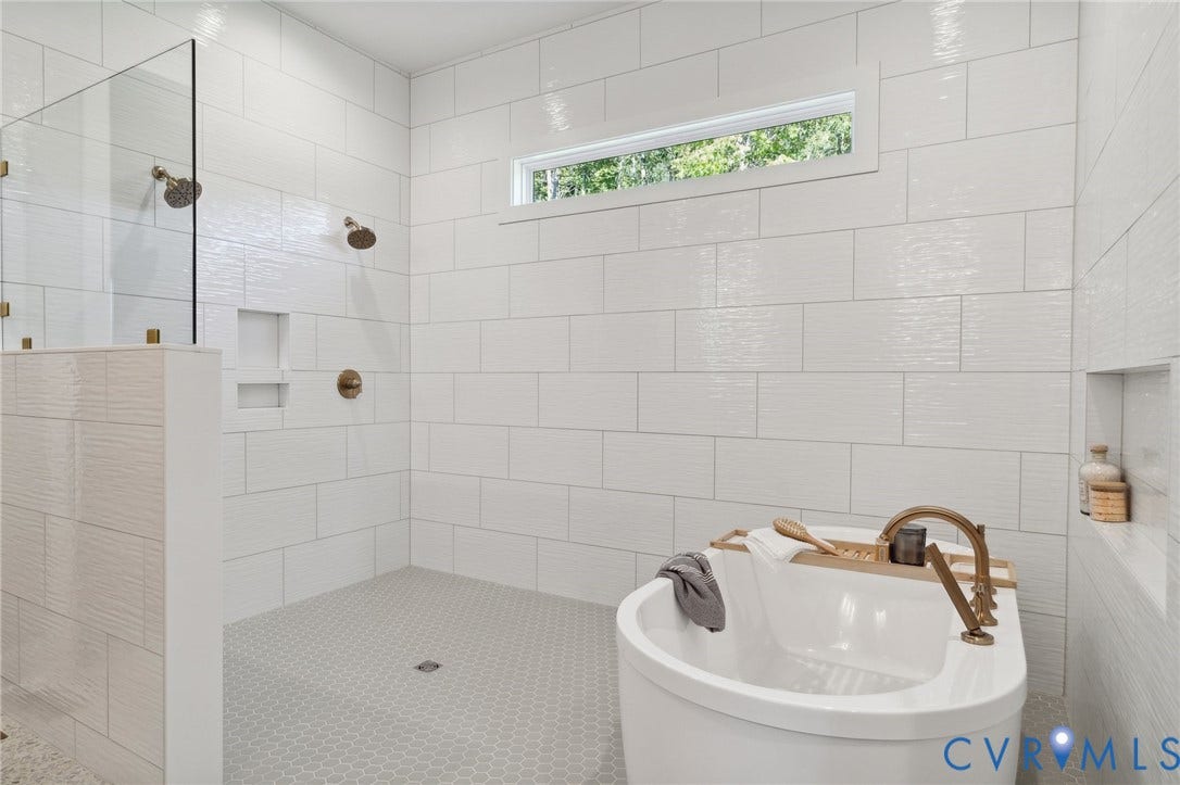 18128 Dogwood Trail Way, Rockville, VA 23146 Walk-in shower with floor-to-ceiling white subway tile, glass partition, dual shower heads, and built-in wall niche, featuring a soaking tub with gold-tone fixtures