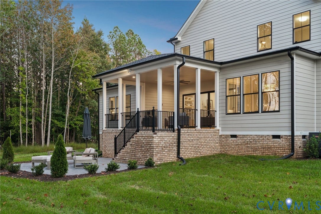 18128 Dogwood Trail Way, Rockville, VA 23146 Rear exterior featuring a covered porch with iron railing, brick foundation, light-toned horizontal siding, and a paver patio