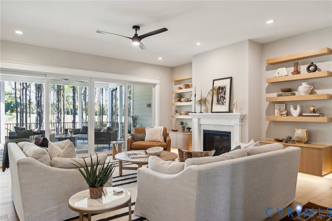 18128 Dogwood Trail Way, Rockville, VA 23146 Living area featuring wood-finish flooring, a fireplace with a mantel, built-in recessed shelving, multi-panel sliding glass doors, and a ceiling fan with integrated lighting