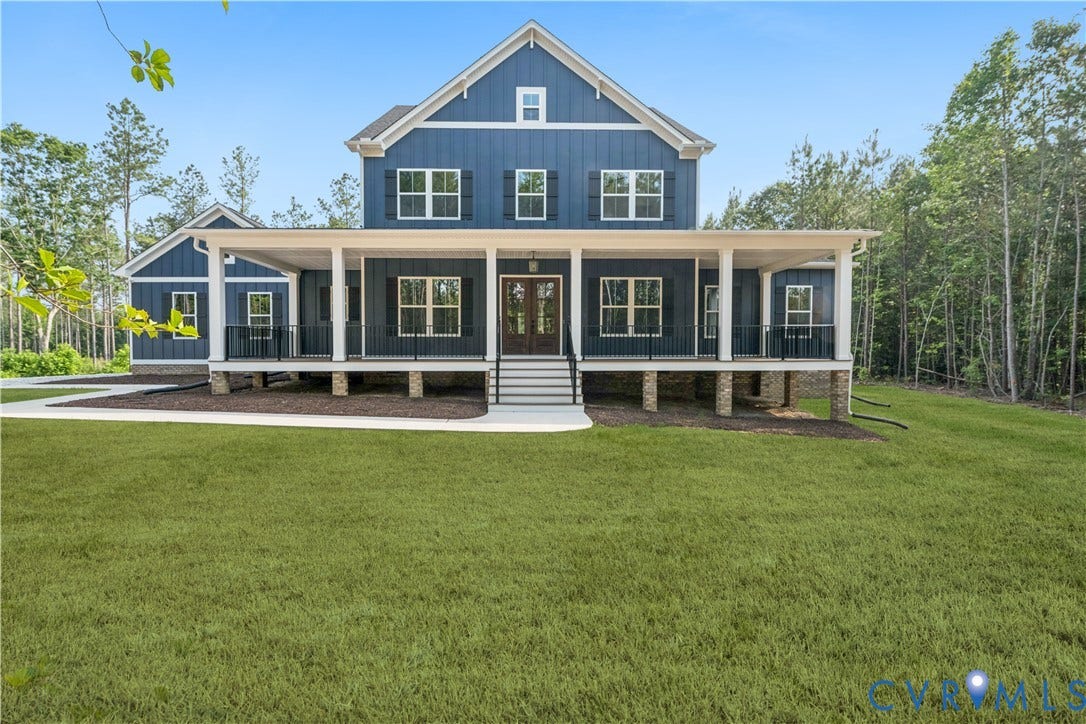 18128 Dogwood Trail Way, Rockville, VA 23146 Two-story residence featuring blue vertical siding, a wraparound porch with white columns, stone-finished foundation piers, and black metal railings