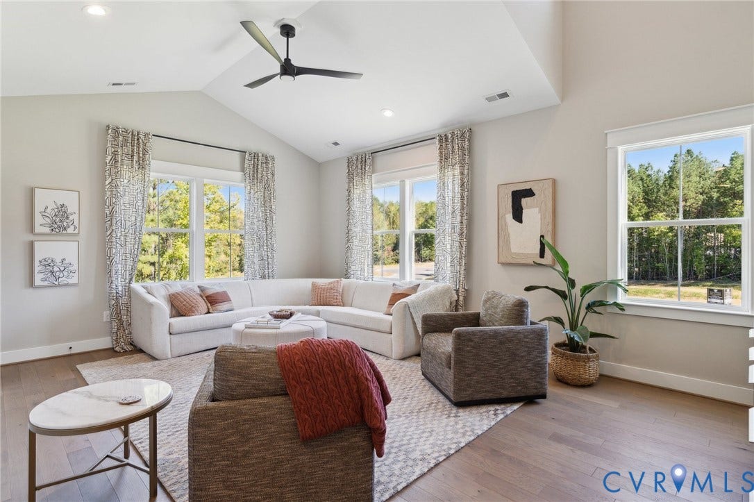 18128 Dogwood Trail Way, Rockville, VA 23146 Vaulted ceilings, wood-finish flooring, recessed lighting, matte black ceiling fan, and large windows with exterior forest scenery