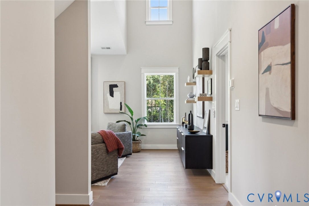 18128 Dogwood Trail Way, Rockville, VA 23146 High-ceiling interior featuring wood-finish flooring, dual-level windows, and wall-mounted wooden shelving
