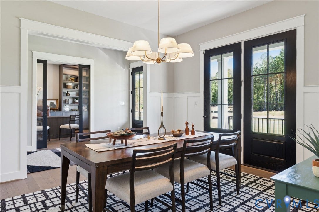 18128 Dogwood Trail Way, Rockville, VA 23146 Dining area featuring crisp board-and-batten wainscoting, polished wood-finish flooring, a multi-arm chandelier with fabric shades, and black-framed glass-paneled exterior doors
