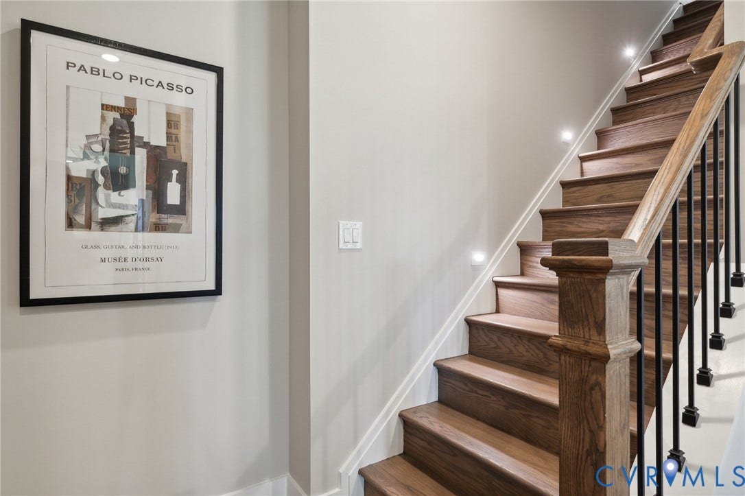 18128 Dogwood Trail Way, Rockville, VA 23146 Staircase featuring wood-finish treads, a substantial wood handrail, matte black metal balusters, and integrated recessed stair lighting