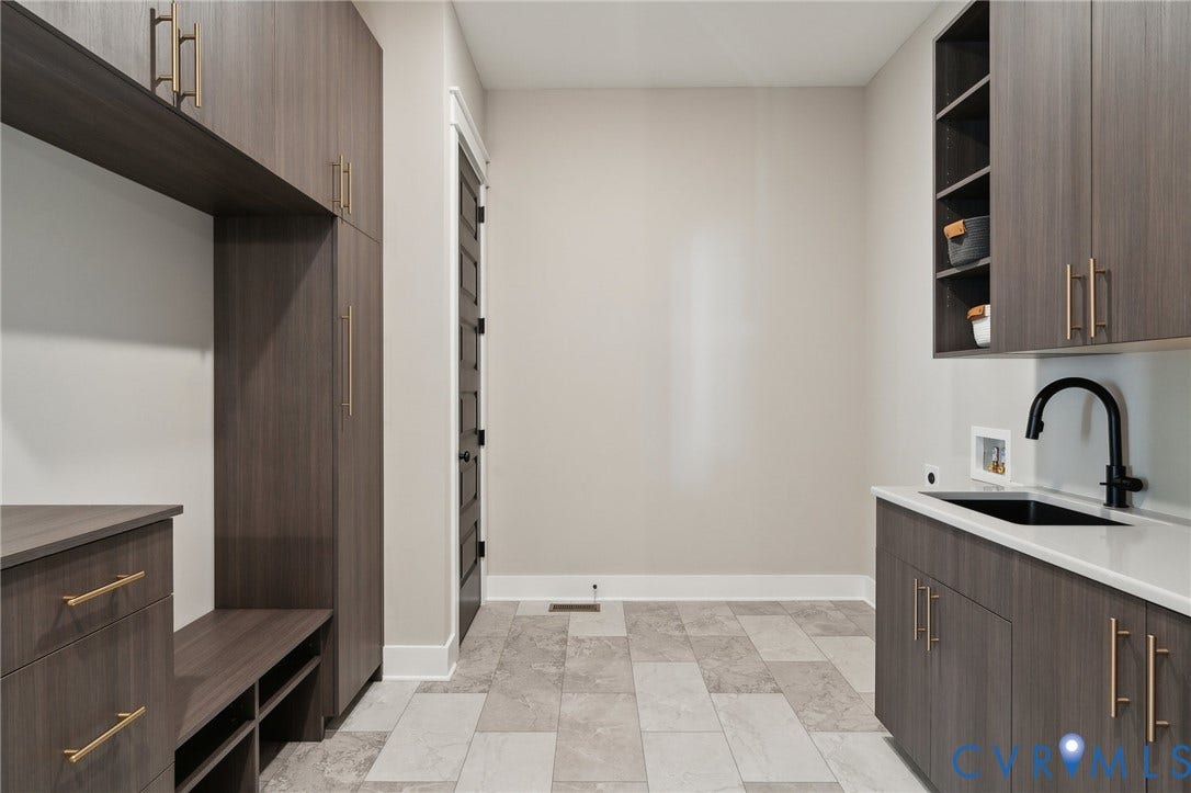18128 Dogwood Trail Way, Rockville, VA 23146 Custom dark-finish cabinetry featuring brushed gold hardware, quartz countertops, drop-in basin with a matte black faucet, and stone-finish tile flooring