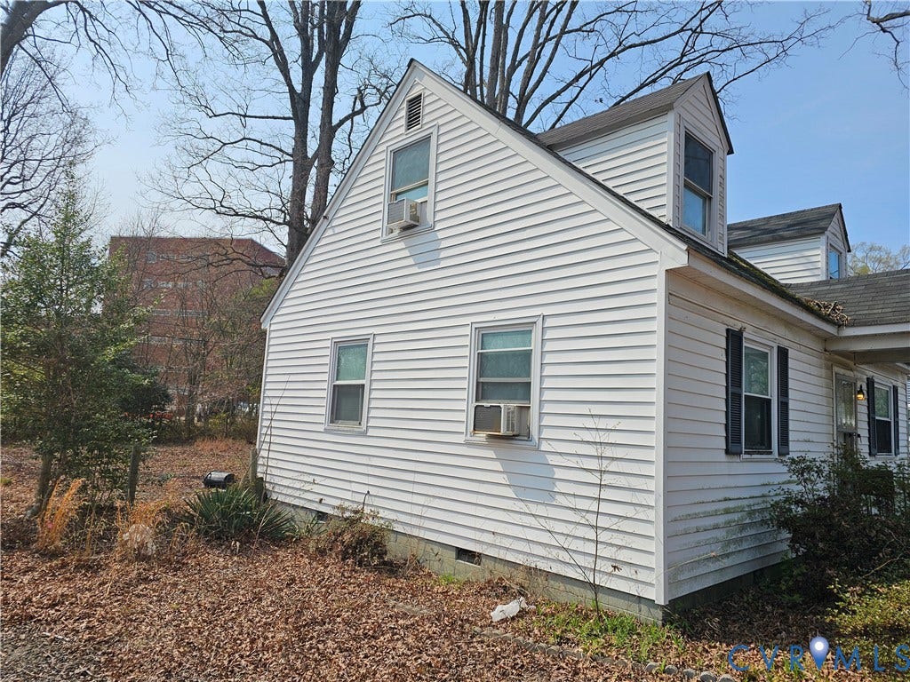 3455 McGuire Drive, McGuire Homes, Richmond, VA 23224 Exterior featuring white horizontal siding, dual gabled dormers, a multi-pitched roof, and multiple window units