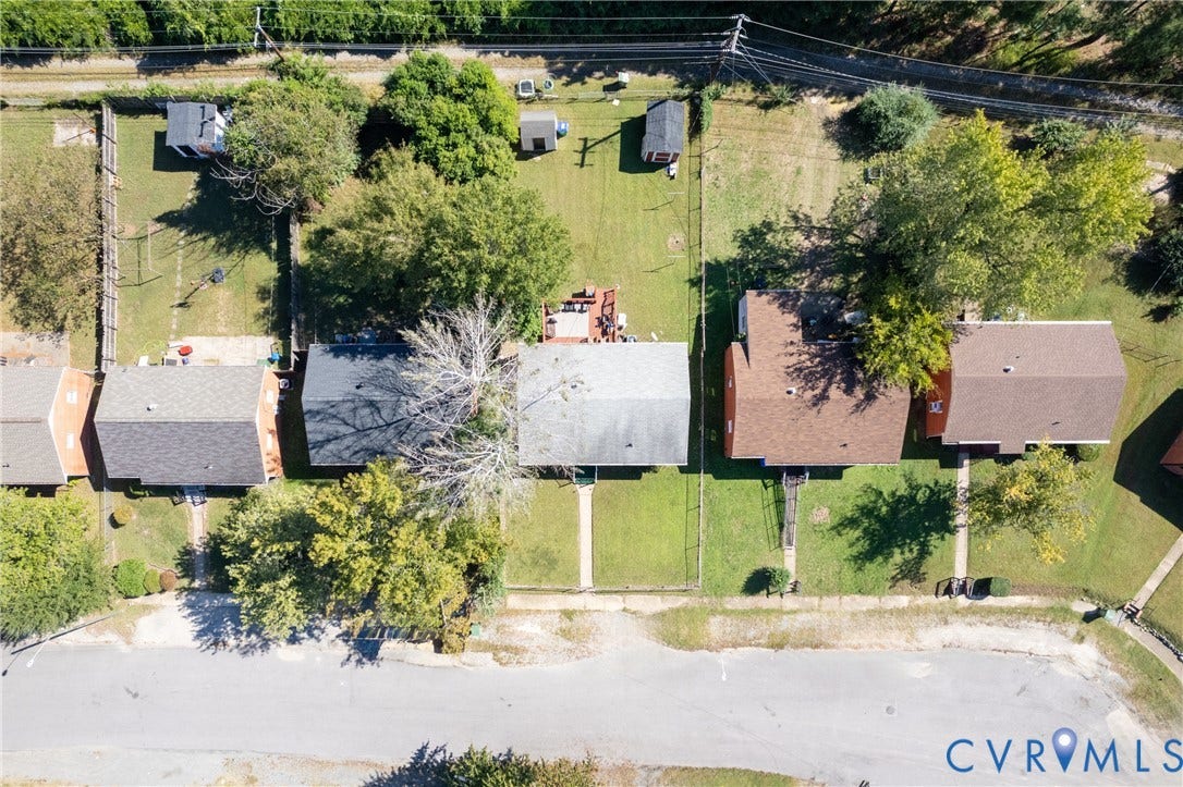 2108 Ridgemont Road, Richmond, VA 23224 Aerial perspective of a residential property featuring an expansive backyard, mature trees, a detached storage structure, and a fenced perimeter