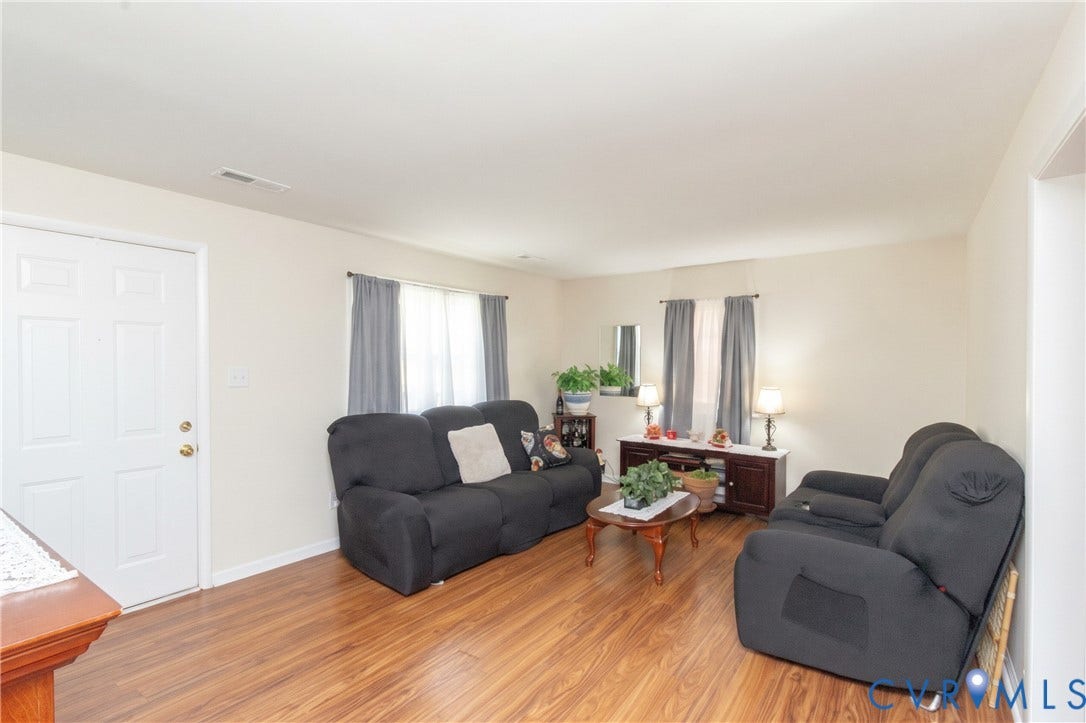 2108 Ridgemont Road, Richmond, VA 23224 Living area featuring wood-finish flooring, two dual-pane windows with trim, and a six-panel entry door