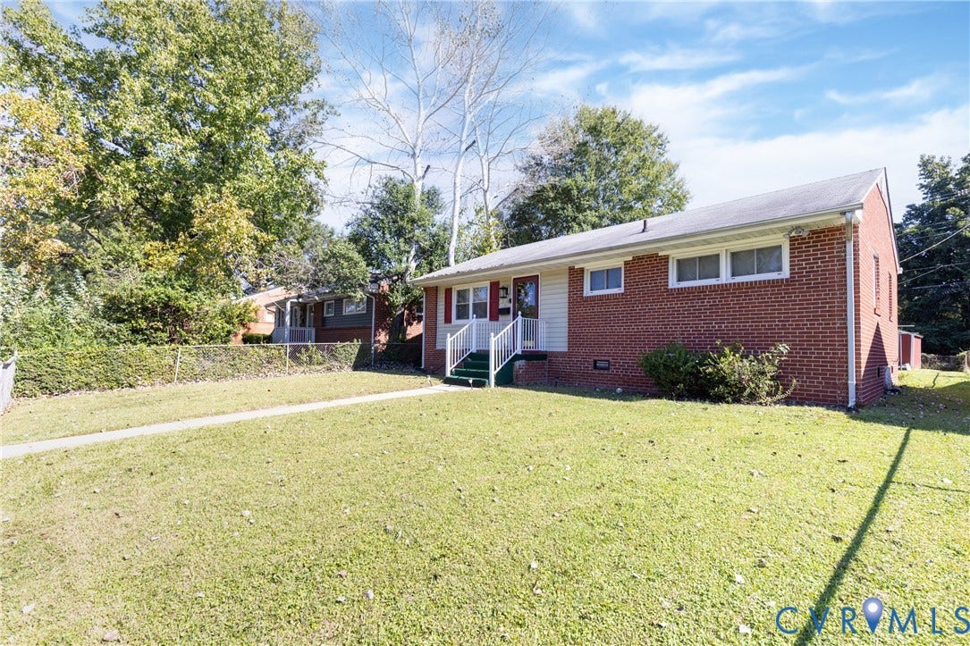 2108 Ridgemont Road, Richmond, VA 23224 Single-story residence featuring a classic red brick exterior, horizontal siding accents, white window shutters, and a front entry with metal railings