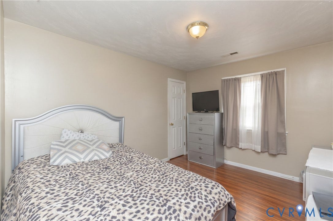 2108 Ridgemont Road, Richmond, VA 23224 Wood-finish flooring, neutral wall paint, and a central dome-style ceiling light fixture