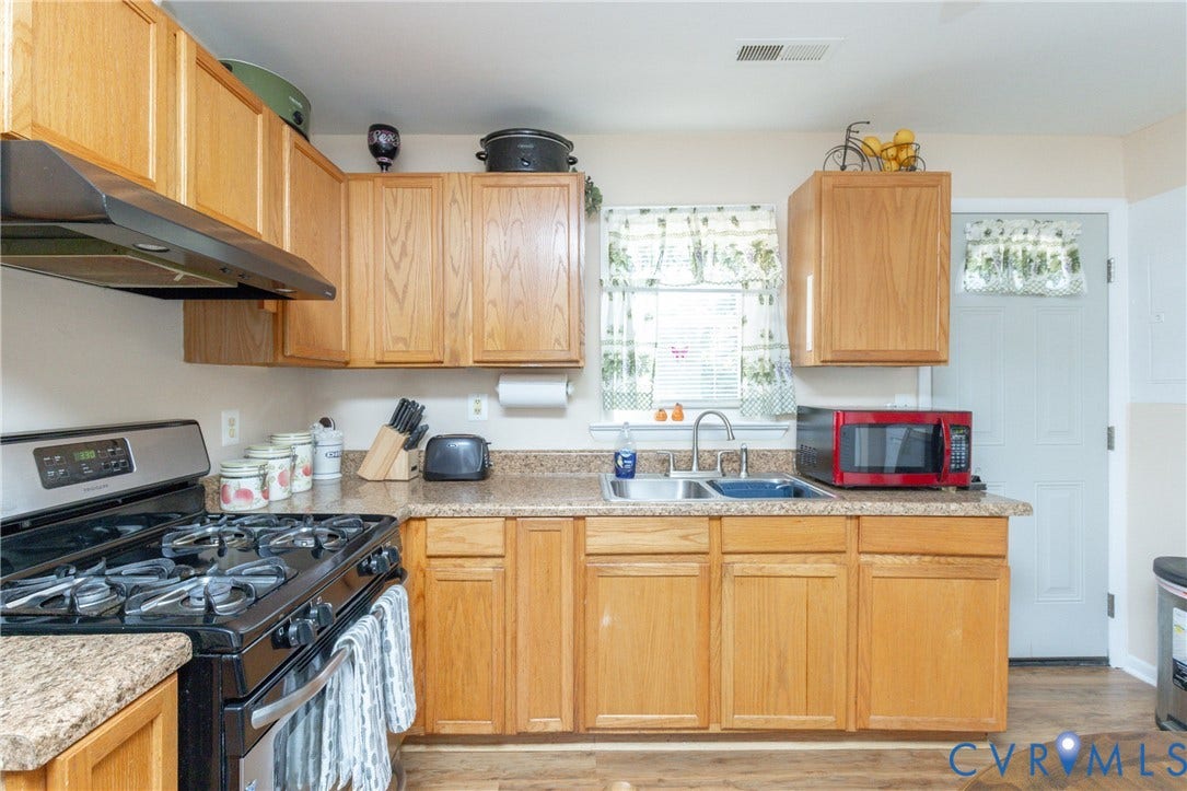 2108 Ridgemont Road, Richmond, VA 23224 Kitchen featuring natural wood cabinetry, stone-finish countertops, stainless steel double-basin sink with pull-down faucet, and built-in black gas range with matching ventilation hood
