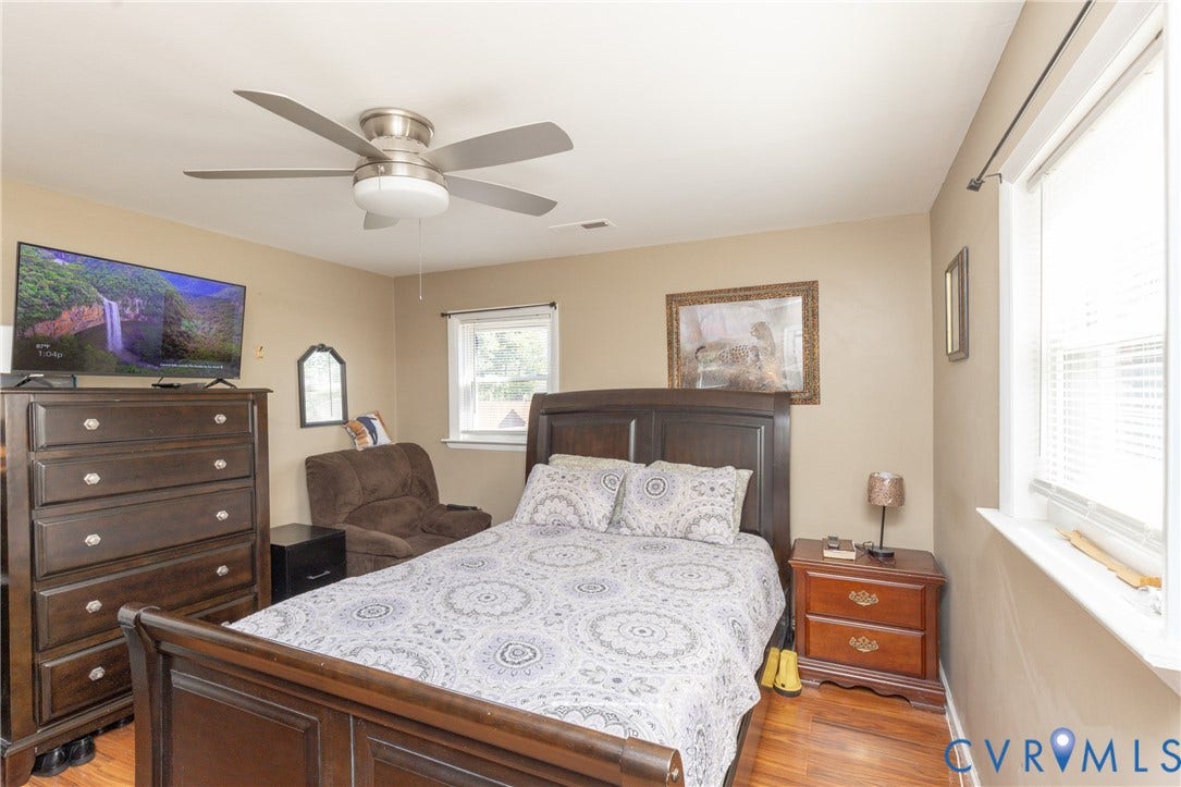 2108 Ridgemont Road, Richmond, VA 23224 Room featuring wood-finish flooring, a neutral color palette, multiple windows, and a ceiling-mounted fan with integrated lighting