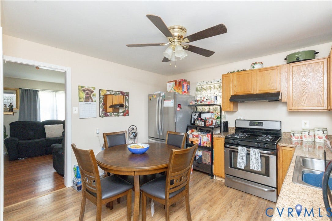 2108 Ridgemont Road, Richmond, VA 23224 Kitchen featuring wood cabinetry, stone-finish countertops, stainless steel appliance suite, and wood-finish flooring with a ceiling-mounted fan