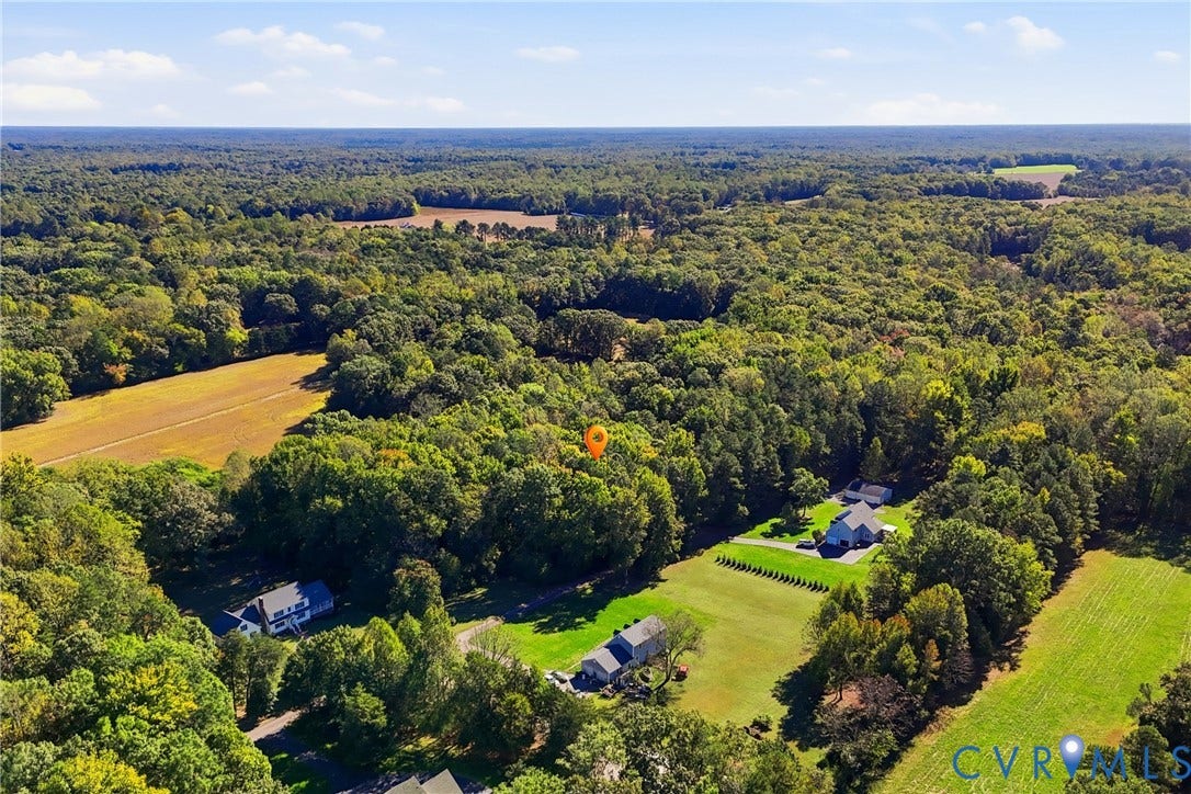 7270 Crossing Oaks Trail, Mechanicsville, VA 23111 Aerial perspective featuring expansive acreage, dense woodland surroundings, cleared grassy lots, and established tree lines