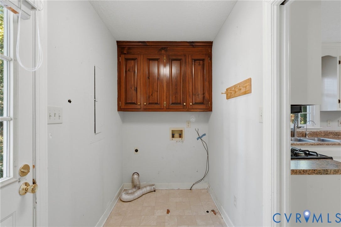 7270 Crossing Oaks Trail, Mechanicsville, VA 23111 Utility space featuring wood-finish upper cabinetry, tiled flooring, and a dedicated exterior access door