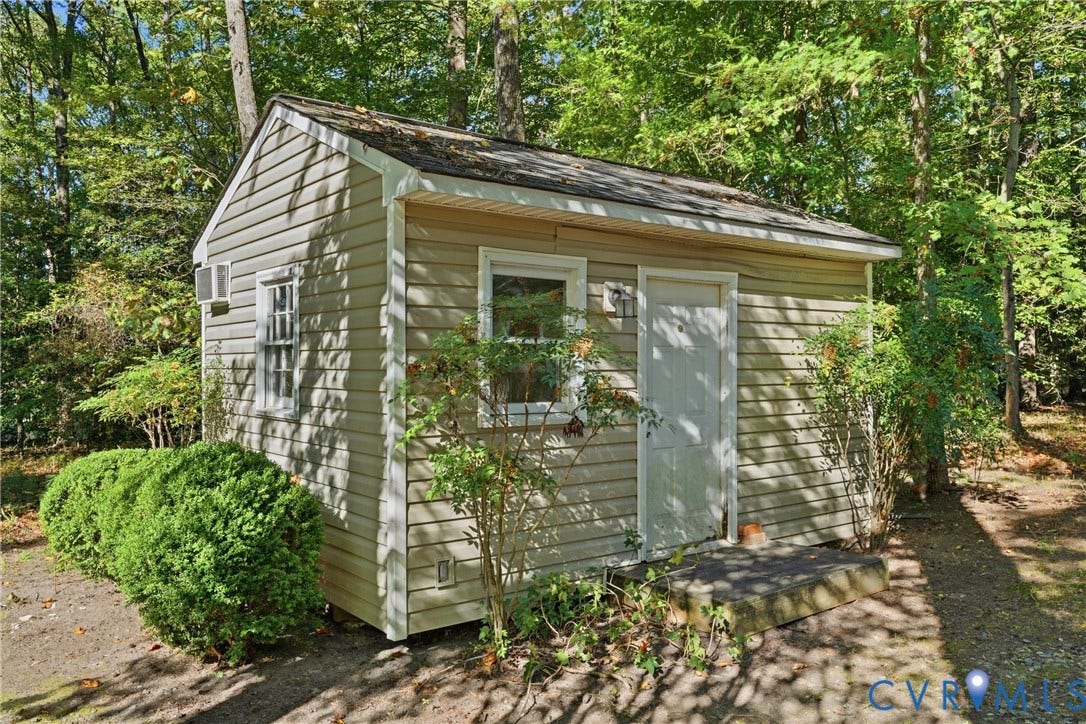 7270 Crossing Oaks Trail, Mechanicsville, VA 23111 Outbuilding featuring vinyl siding, shingle roof, white trim, single-entry door, and installed wall-mounted cooling unit