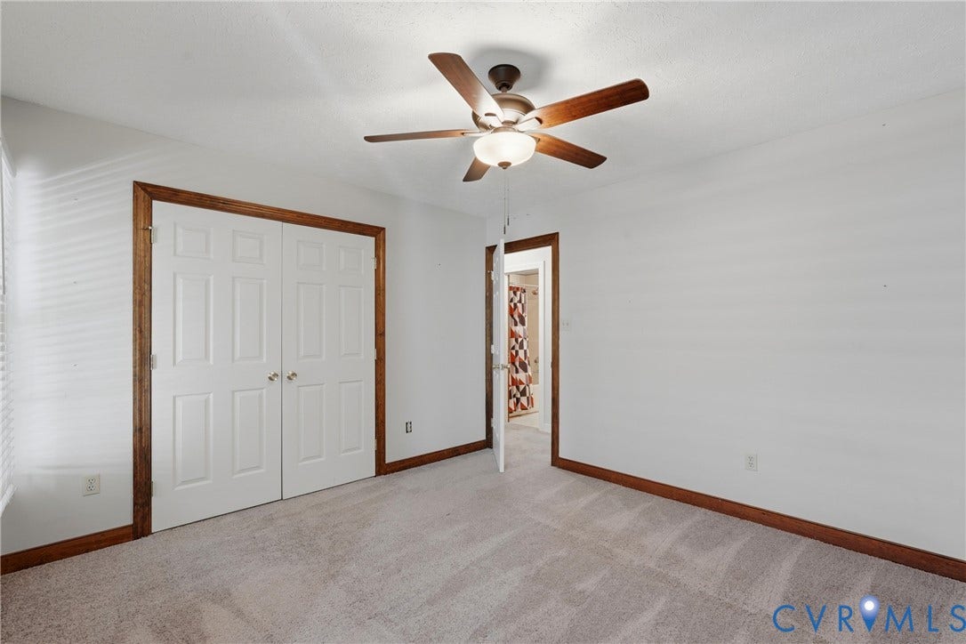 7270 Crossing Oaks Trail, Mechanicsville, VA 23111 Neutral-toned carpeting, wood-trimmed door frames, double-panel closet doors, and a ceiling fan with integrated lighting