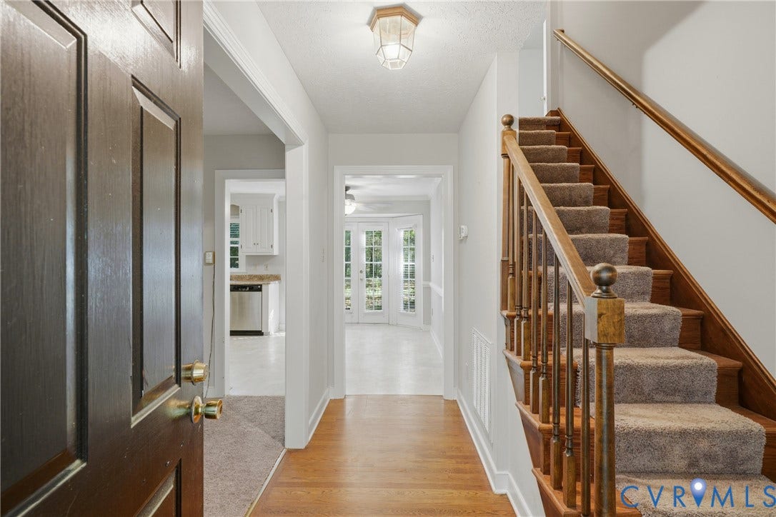 7270 Crossing Oaks Trail, Mechanicsville, VA 23111 Foyer featuring wood-finish flooring, staircase with wood handrail, balusters, and carpeted treads, and overhead lantern-style ceiling light