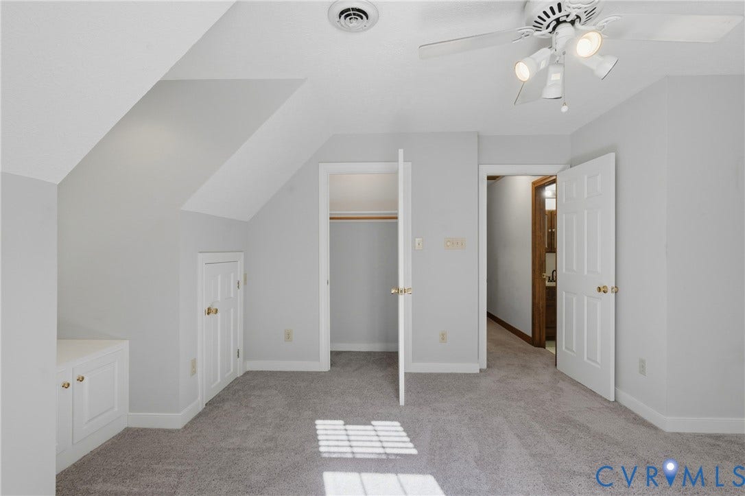 7270 Crossing Oaks Trail, Mechanicsville, VA 23111 Neutral-toned bedroom featuring slanted ceilings, built-in cabinetry, walk-in closet, and a multi-bulb ceiling fan with integrated lighting
