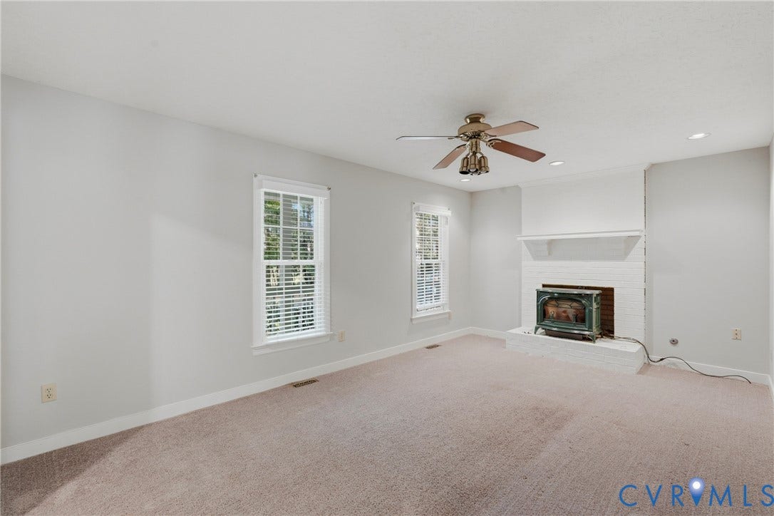 7270 Crossing Oaks Trail, Mechanicsville, VA 23111 Brick fireplace featuring a hearth and integrated wood stove, double-hung windows, recessed lighting, and a ceiling fan