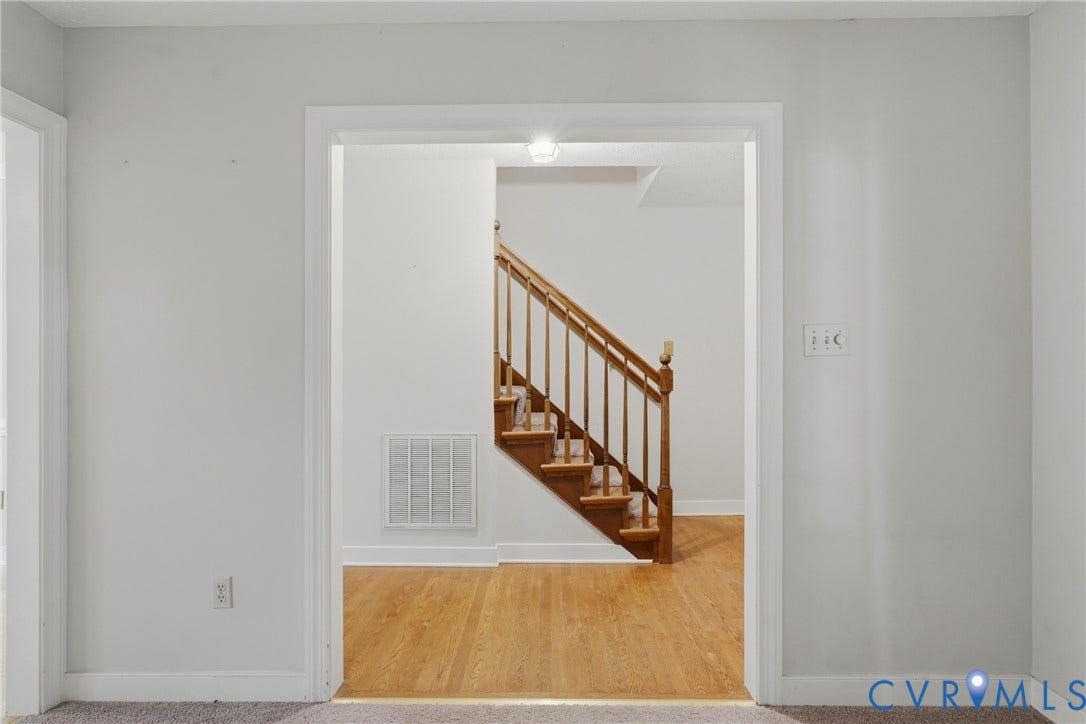 7270 Crossing Oaks Trail, Mechanicsville, VA 23111 Interior doorway featuring wood-finish flooring and a staircase with a wooden balustrade