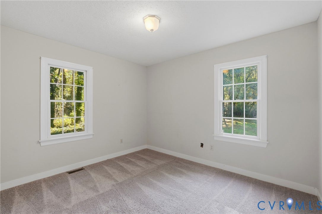 7270 Crossing Oaks Trail, Mechanicsville, VA 23111 Room featuring neutral wall tones, wall-to-wall carpeting, two multi-pane windows with white trim, and a centered flush-mount ceiling light fixture