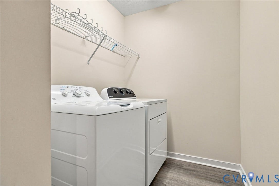 Utility area featuring neutral wall paint, wood-finish flooring, and a white wire shelving unit