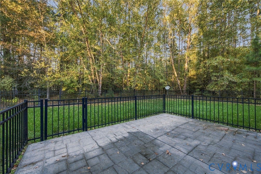 Paver patio featuring a fenced rear yard with mature trees
