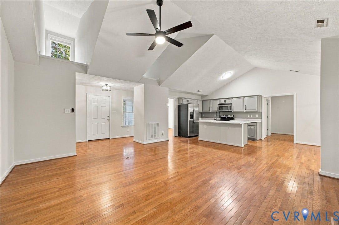 Vaulted ceilings, wood-finish flooring, kitchen island with countertop, and overhead ceiling fan