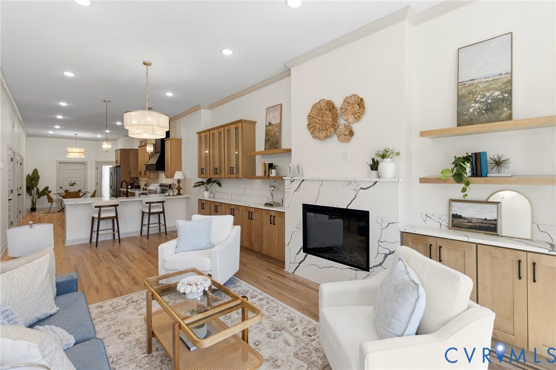 3104 E Broad Street, Richmond, VA 23223 Living area featuring a fireplace with a stone-surround facade, wood-finish cabinetry, natural wood floating shelves, wood-finish flooring, and recessed lighting