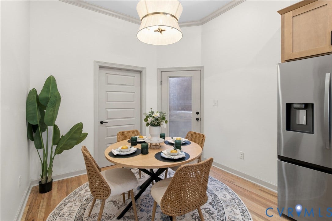 3104 E Broad Street, Richmond, VA 23223 Wood-finish flooring, stainless steel refrigerator, neutral wall tones, multi-panel interior door, and modern drum pendant lighting