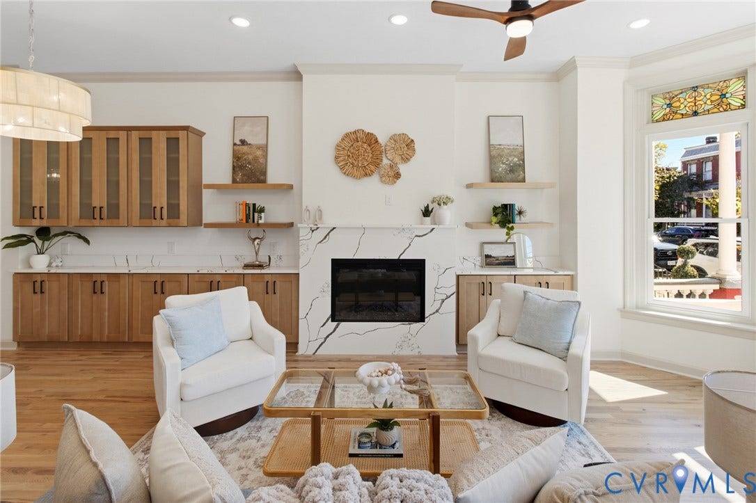 3104 E Broad Street, Richmond, VA 23223 Living area featuring a fireplace with a veined stone-finish surround, custom light-toned wood cabinetry, built-in shelving, recessed lighting, and a stained-glass window accent