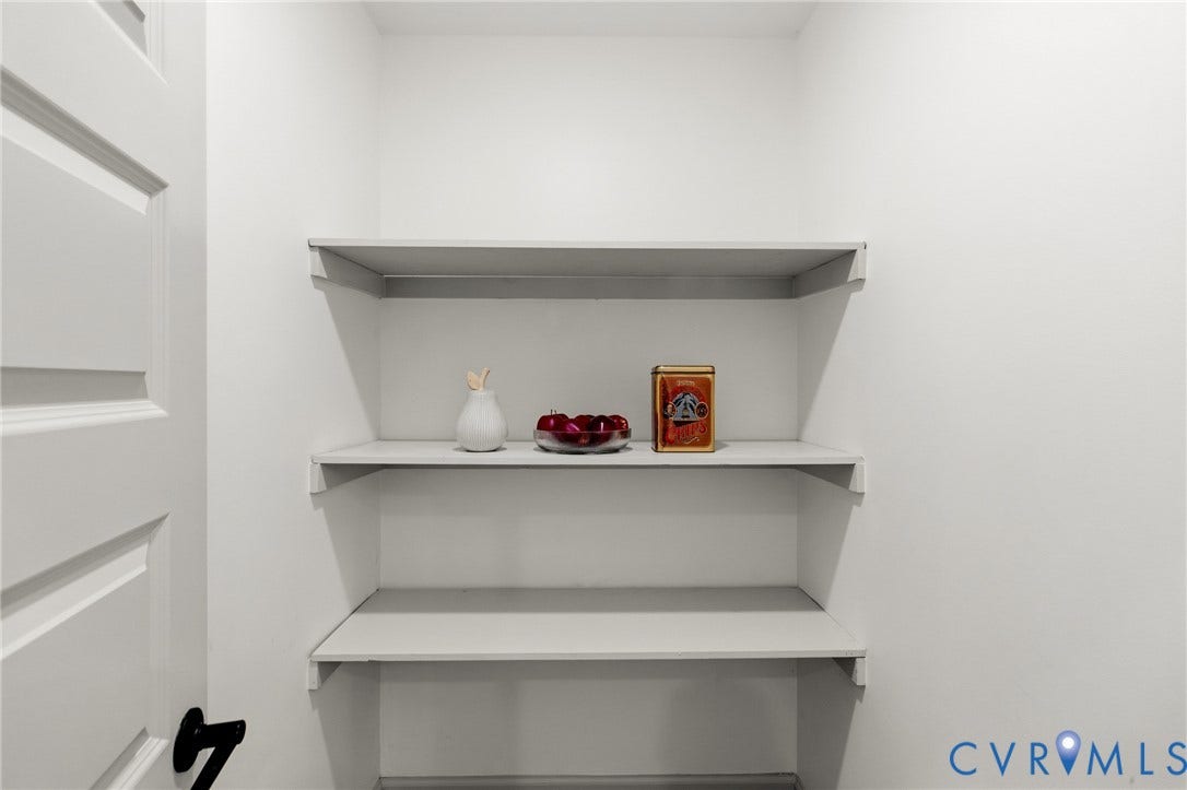 3104 E Broad Street, Richmond, VA 23223 Storage area featuring three fixed shelves and a paneled door with a matte black lever handle