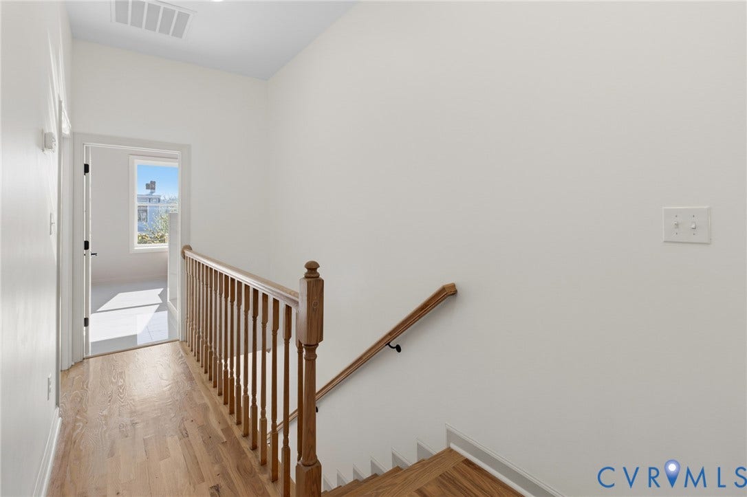 3104 E Broad Street, Richmond, VA 23223 Landing area featuring wood-finish flooring, a wooden staircase with balustrades, and a natural wood handrail