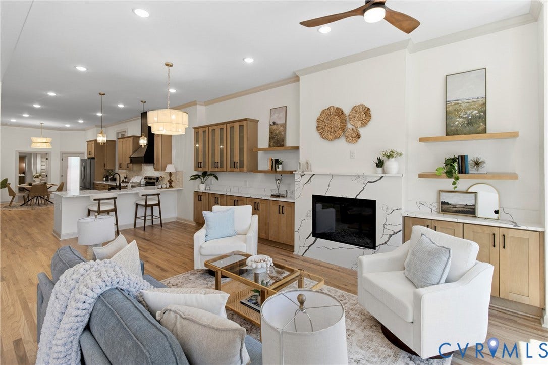 3104 E Broad Street, Richmond, VA 23223 Open-concept living space featuring wood-finish flooring, a fireplace with a stone-surround facade, custom wood cabinetry, integrated floating shelving, and recessed ceiling lighting