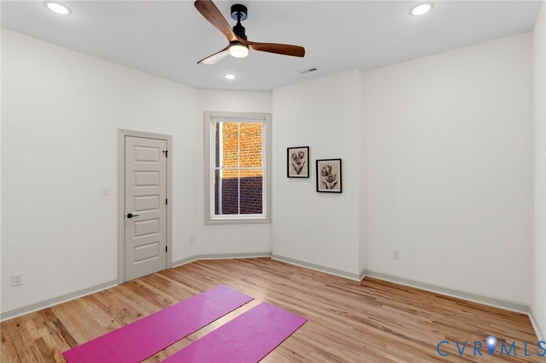 3104 E Broad Street, Richmond, VA 23223 Room featuring wood-finish flooring, recessed lighting, a modern three-blade ceiling fan, and a single-hung window with exterior brick detail
