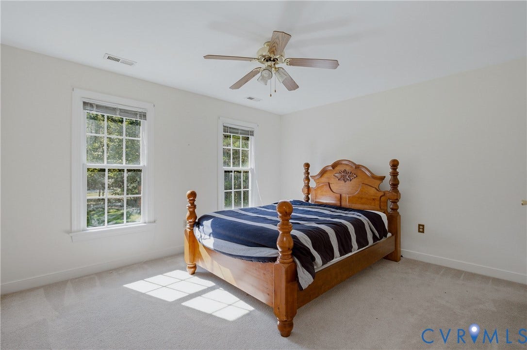 11400 County Drive, Prince George, VA 23842 Neutral interior featuring wall-to-wall carpeting, two multi-pane windows with trim, and a ceiling-mounted fan with integrated light fixture