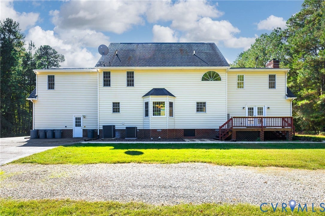 11400 County Drive, Prince George, VA 23842 Two-story exterior featuring light-colored siding, a brick foundation, a bay window, an arched window, and an attached elevated wooden deck