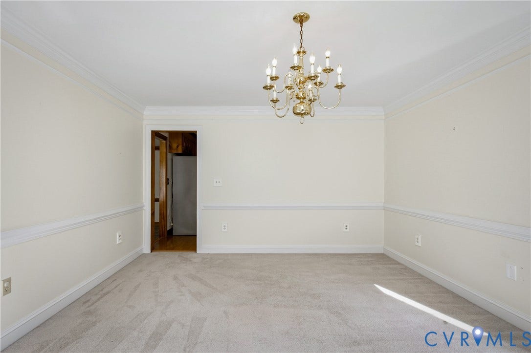 11400 County Drive, Prince George, VA 23842 Neutral-toned carpeted room featuring crown molding, chair rail trim, and a brass chandelier