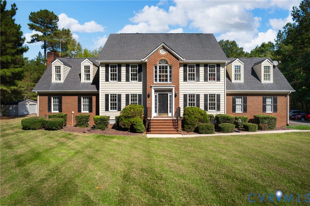 11400 County Drive, Prince George, VA 23842 Two-story Colonial exterior featuring a brick and vinyl siding facade, shingled roof, multiple dormer windows, and a covered brick-step entryway