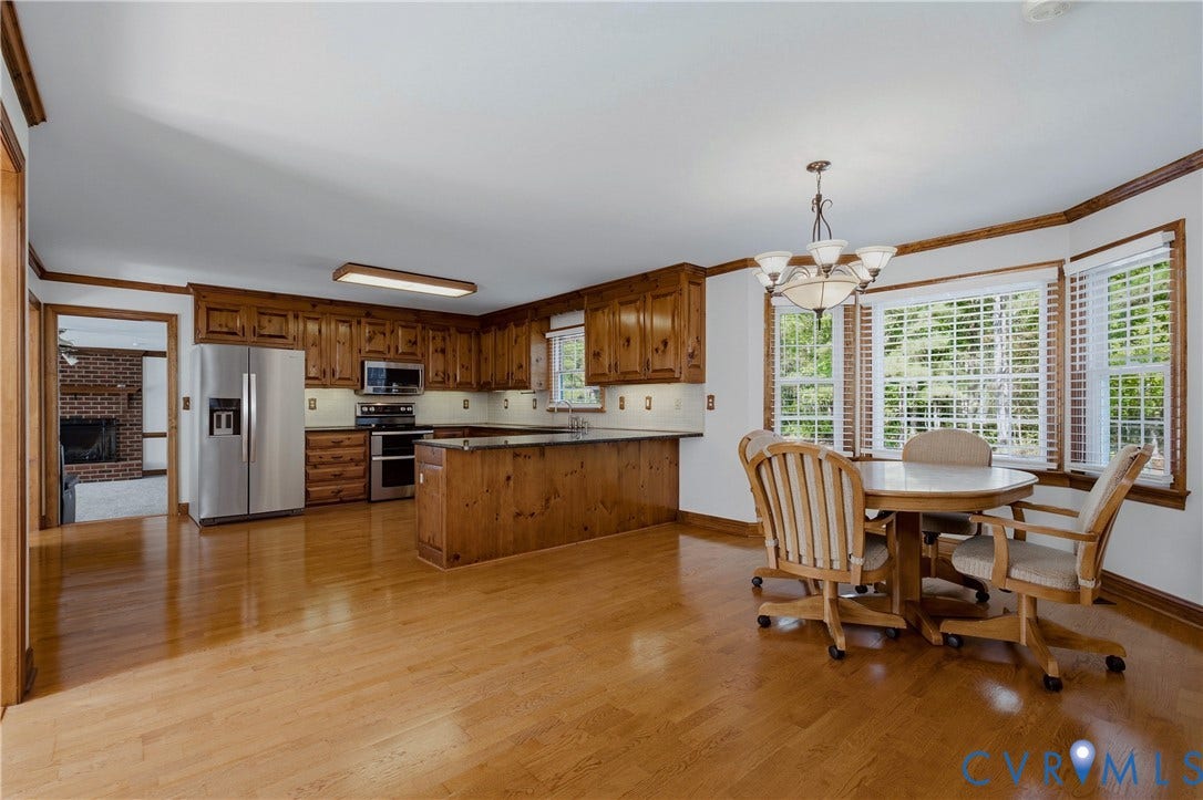 11400 County Drive, Prince George, VA 23842 Kitchen featuring wood cabinetry, stainless steel appliances, dark countertops, and wood-finish flooring