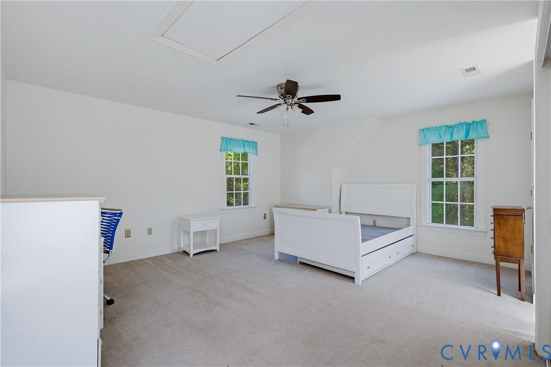 11400 County Drive, Prince George, VA 23842 Neutral-toned wall-to-wall carpeting, two double-hung windows with grid muntins, and a ceiling fan with integrated lighting