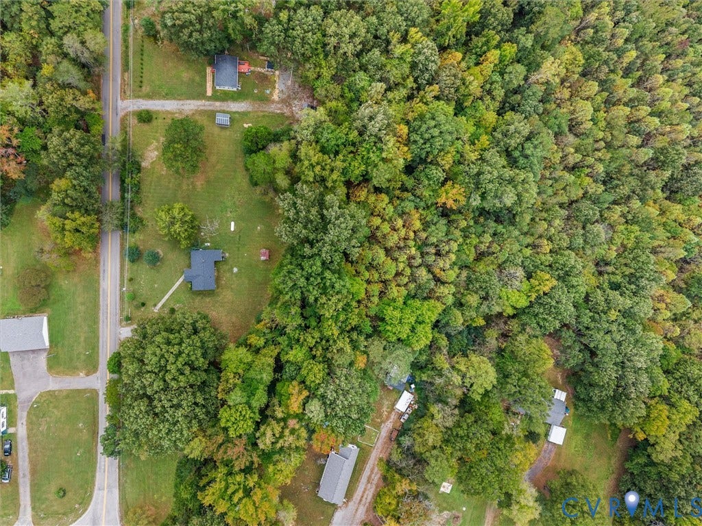 8631 Kimages Road, Charles City, VA 23030 Aerial view of expansive lot featuring open grassy grounds, mature woodland coverage, and direct paved road access