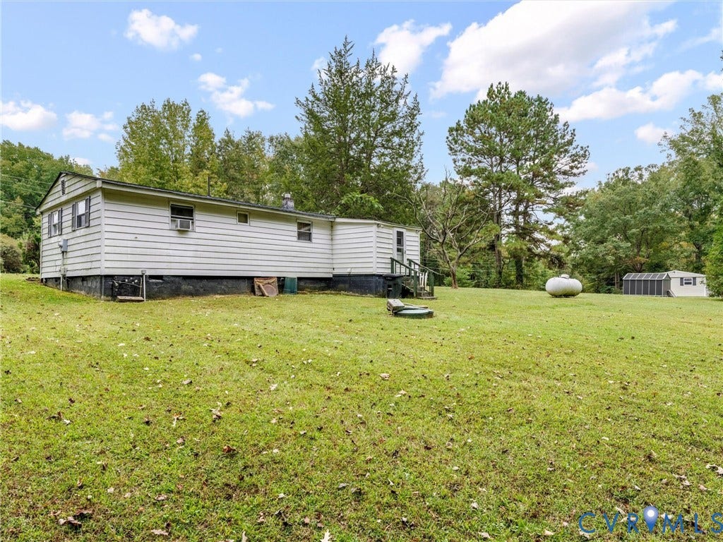 8631 Kimages Road, Charles City, VA 23030 Siding exterior with a grass lawn, mature trees, and a detached structure