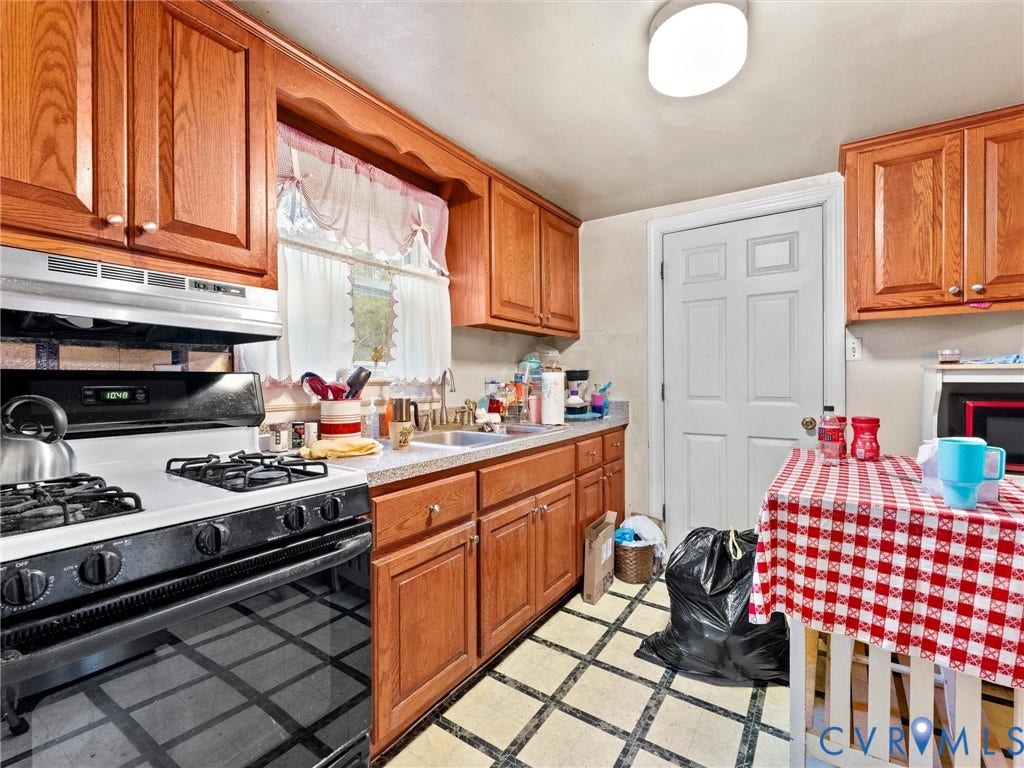 8631 Kimages Road, Charles City, VA 23030 Kitchen featuring natural wood cabinetry, gas range with an overhead exhaust hood, stainless steel sink, and grid-patterned tile flooring