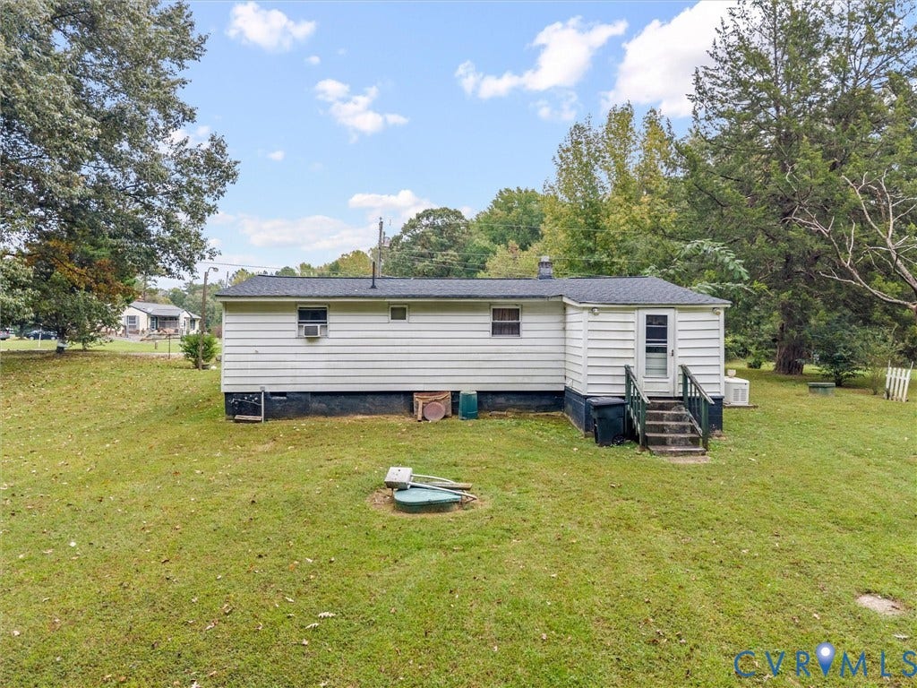 8631 Kimages Road, Charles City, VA 23030 Single-story residence featuring white horizontal siding, an asphalt shingle roof, and a rear exterior staircase with a wooden railing